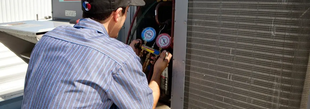 HVAC technician servicing a condenser unit in Plaquemine