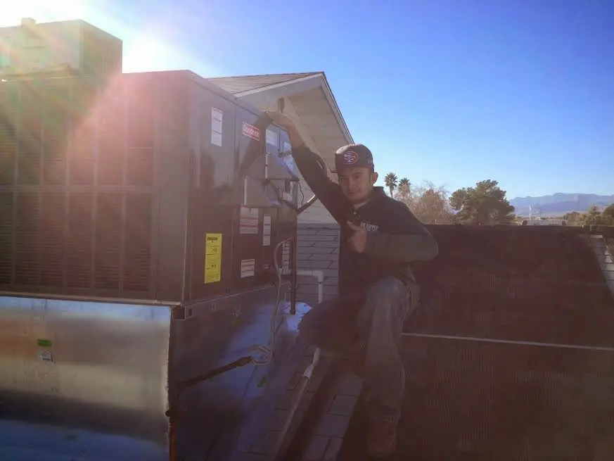 HVAC technician performing Boiler Repair on a rooftop unit in Plaquemine